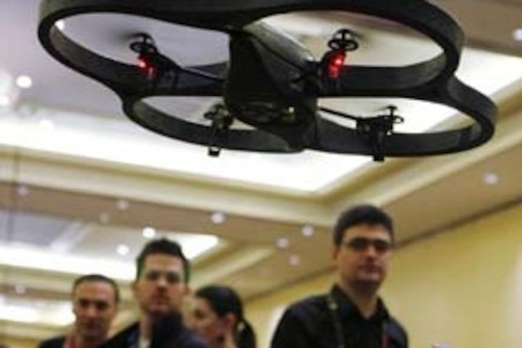 Parrot A.R. Drone, a four-propeller flying drone that connects to an Apple iPhone or iPod Touch via Wi-Fi with a video-streaming camera hovers at the Consumer Electronics Show (CES) in Las Vegas, Tuesday, Jan. 5, 2010. The showroom floor opens on Thursday, Jan. 7, 2010. (AP Photo/Paul Sakuma)