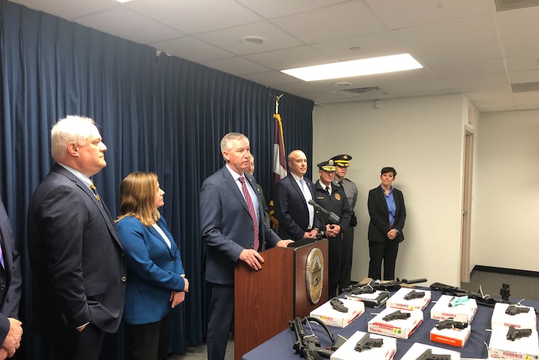 Montgomery County District Attorney Kevin Steele (center) announced the arrests of eight members of a gun-trafficking ring that prosecutors say purchased nearly 100 guns.