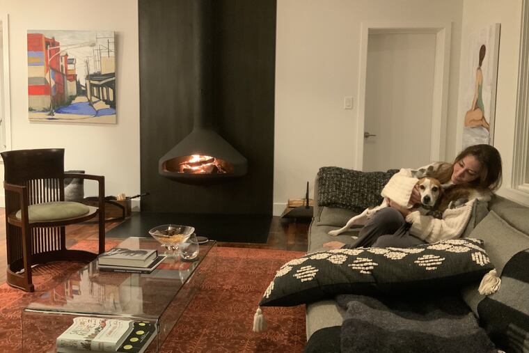 Laura Berland and rescue Beagle, Cammie, cuddle in front of their wood-burning fireplace, which efficiently heats their entire living room and kitchen.