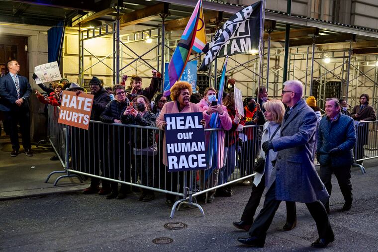 Activist Melissa Robbins, center, holds a “heal our human race” sign and leads protesters outside the Union League as guests arrive for the event honoring Florida Gov. Ron DeSantis on Jan. 24, 2023.
