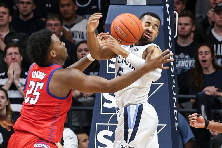 Phil Booth gets fouled by DePaul's Femi Olujobi (25) late in the Wildcats' victory.
