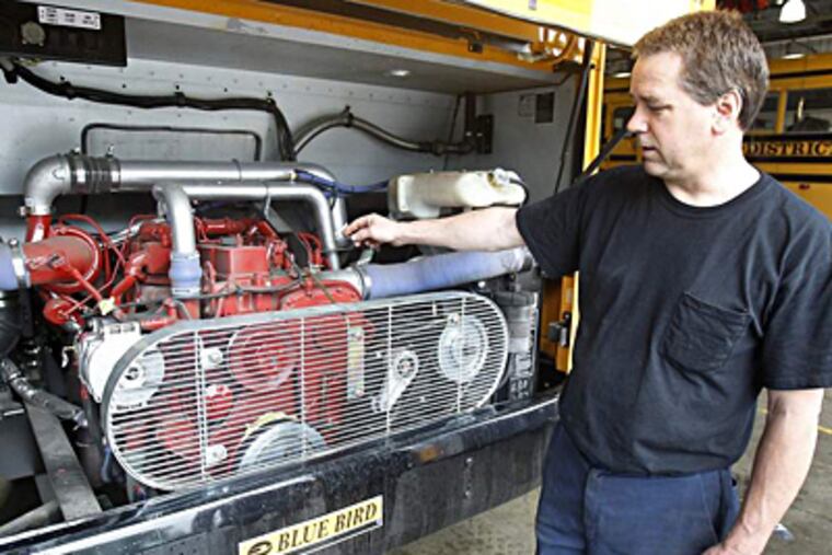 Lower Merion School District lead mechanic Bryan Bohn with one of his buses' natural-gas engines. It converted half its fleet of 113 buses to natural gas in the 1990s. AKIRA SUWA / Staff Photographer