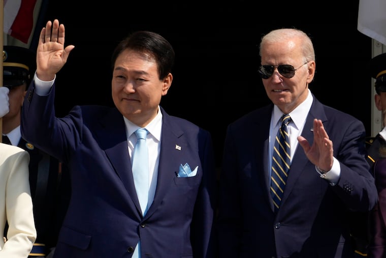 President Joe Biden and South Korea's President Yoon Suk Yeol wave from the Blue Room Balcony during a State Arrival Ceremony on the South Lawn of the White House on Wednesday in Washington.