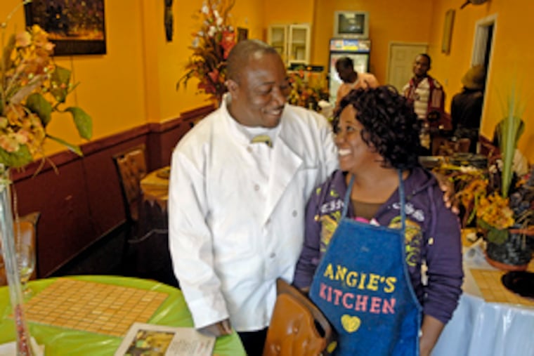 Augustine Manyeh, who runs Angie's Kitchen in the 600 block of South 52d Street, chats with his sister, Comfort Manyeh. Augustine Manyeh said he fears Liberia will not able to absorb all the refugees who will be forced to return.