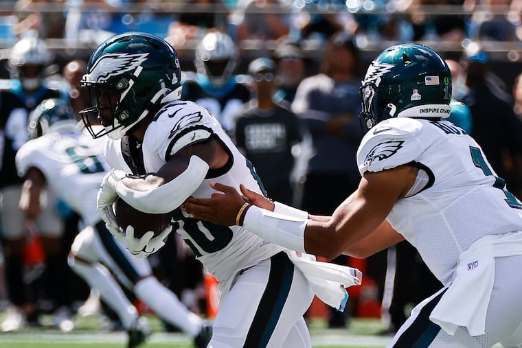 Eagles running back Miles Sanders takes the football from quarterback Jalen Hurts against the Carolina Panthers on Sunday in Charlotte.