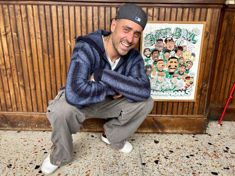 Pasta Pooks co-owner Victor-Alex "Coach Vic" Petrenko poses in his restaurant next to some of his Eagles Super Bowl nostalgia.