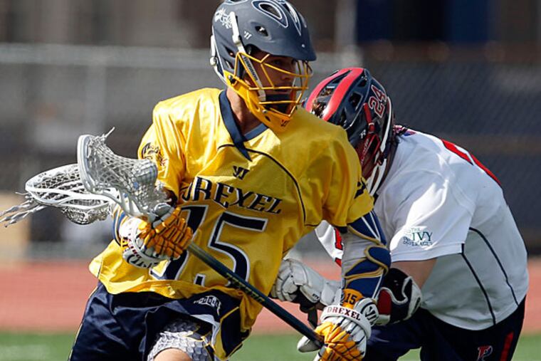 Drexel's Cole Shafer runs with the ball against Penn's Chris Hilburn. (Yong Kim/Staff Photographer)