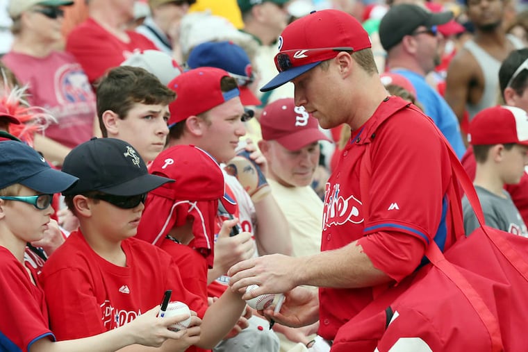 Phillies' third baseman Cody Asche signs his autograph for fans before the Phillies played the Atlanta Braves in a spring training exhibition game on Monday, March 10, 2014. ( Yong Kim / Staff Photographer )