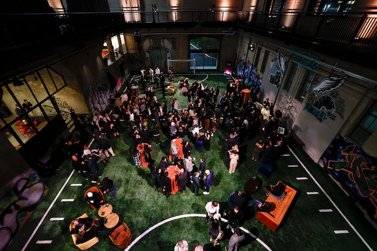 Guests gather in the turf field during the Ballers' grand opening party on Friday. Ballers is a social sports venue that features pickleball, padel, golf simulators, and food and drink options.