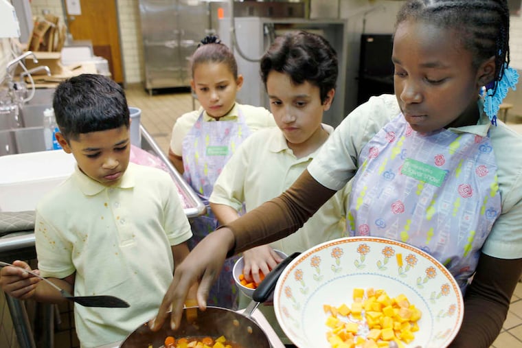 (From left) Yariel Fernandez, Lixjohanne Alicea, Mark Ramirez, and Kareema Brown add ingredients to pan.