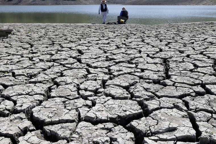 FILE - This March 13, 2014 file photo shows cracks in the dry bed of the Stevens Creek Reservoir in Cupertino, Calif. The Obama administration is more certain than ever that global warming is changing Americans' daily lives and will worsen — conclusions that scientists will detail in a massive federal report to be released Tuesday, May 6, 2014. (AP Photo/Marcio Jose Sanchez, File)