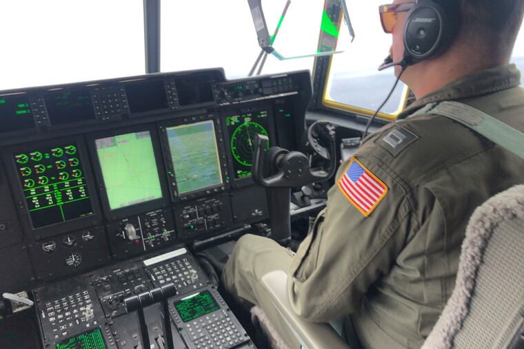 In this image provided by the U.S. Coast Guard, a crew member sits aboard a Coast Guard HC-130 Hercules airplane based at Coast Guard Air Station Elizabeth City, N.C., as it flies about 900 miles East of Cape Cod, Mass., during the search for the 21-foot submersible, Titan, last week.