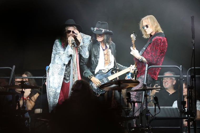 Aerosmith members (from left) lead singer Steven Tyler, guitarist Joe Perry and bassist Tom Hamilton performing during their Peace Out farewell tour at the Wells Fargo Center in South Philadelphia on Saturday.