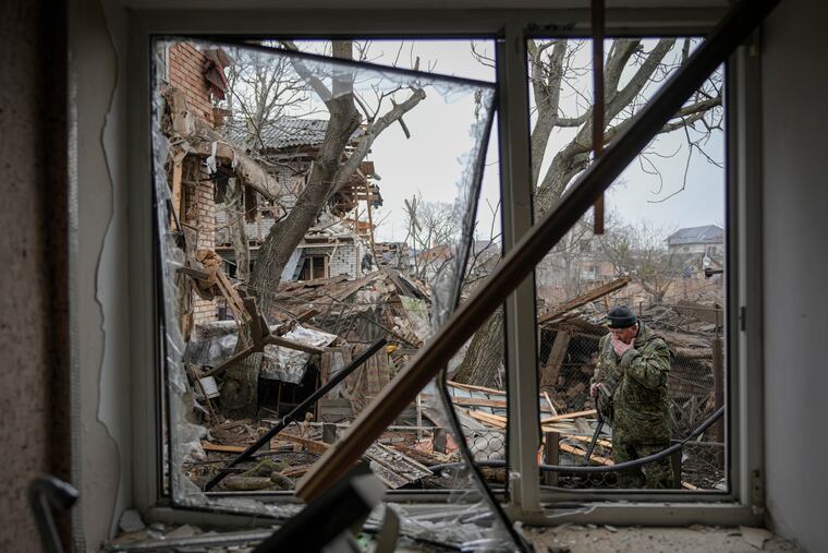 Andrey Goncharuk, 68, a member of territorial defense wipes his face in the backyard of a house that was damaged by a Russian airstrike, according to locals, in Gorenka, outside the capital Kyiv, Ukraine, Wednesday, March 2, 2022. Russia renewed its assault on Ukraine's second-largest city in a pounding that lit up the skyline with balls of fire over populated areas, even as both sides said they were ready to resume talks aimed at stopping the new devastating war in Europe.