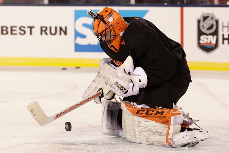 Flyers goaltender Brian Elliott saves the puck wearing a video camera on his helmet during practice at Lincoln Financial Field on Feb. 22. He defeated Pittsburgh in the Stadium Series matchup the next night.
