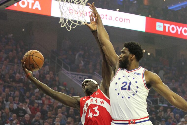 Sixers center Joel Embiid (21) fouls the Toronto Raptors' Pascal Siakam on May 5, 2019, at the Wells Fargo Center in during Game 4 of the Eastern Conference semifinals.