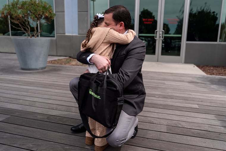 Milenko Faria, whose wife, Rubeliz Bolivar, is in immigration custody, hugs their daughter, Milena, after his asylum interview at the U.S. Citizenship and Immigration Services facility in Tustin, Calif., Thursday, April 16, 2026.