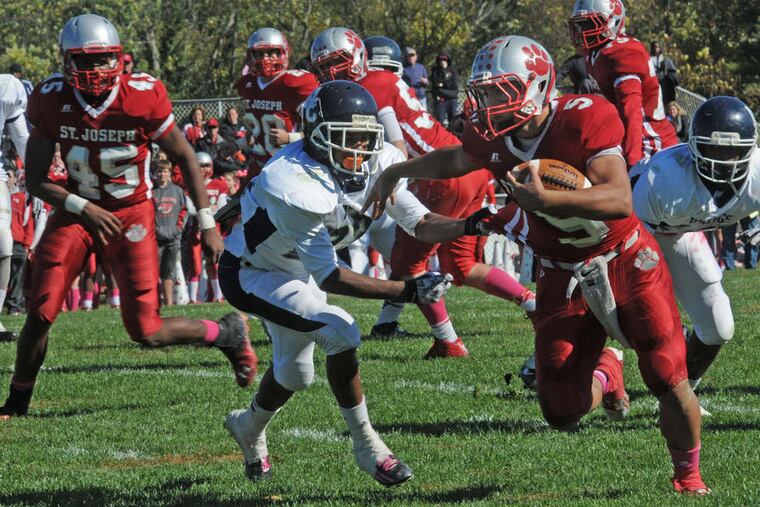 St. Joseph fullback C.J. LaFragola fends off a tackler during an October game. (APRIL SAUL / Staff Photographer)