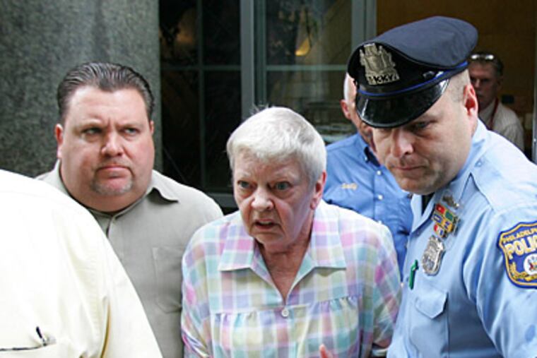 Rosalyn Harrison, sister of the late office Walter T. Barclay, is escorted from the courtroom by John McNesby, president of FOP Lodge #5. (David Swanson / Staff Photographer)