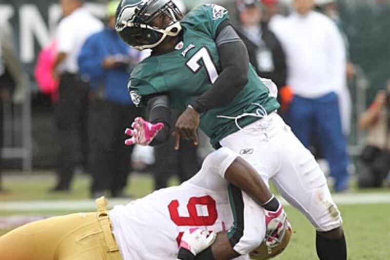 Michael Vick throws the ball away as the 49ers' Justin Smith comes in for the tackle in the second quarter. (Charles Fox/Staff Photographer)