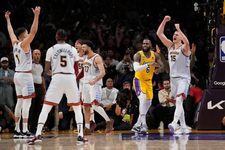 Denver Nuggets center Nikola Jokic (15) celebrates after Los Angeles Lakers forward LeBron James (center) was stopped on a layup attempt as time expired in Game 4 of the Western Conference finals.