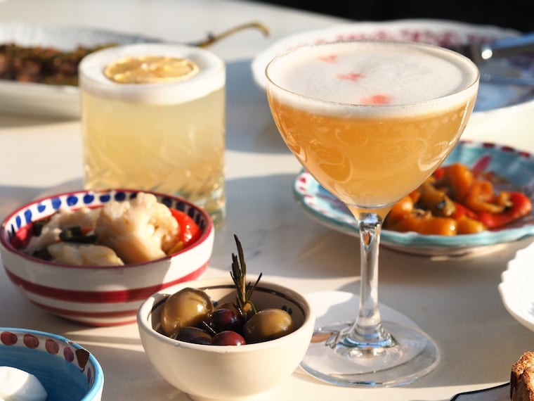 A selection of complimentary aperitivo snacks alongside two cocktails at Sorellina, 699 N. Broad St.