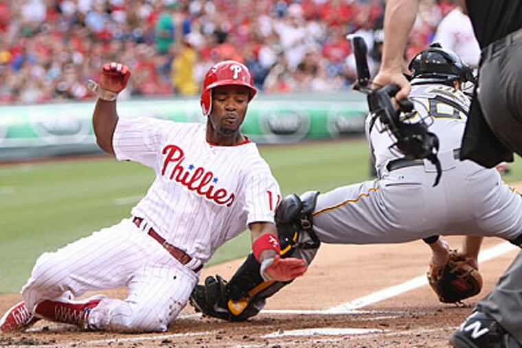 Jimmy Rollins slides past Pirates catcher Rod Barajas to score a run in the first inning. (Steven M. Falk/Staff Photographer)