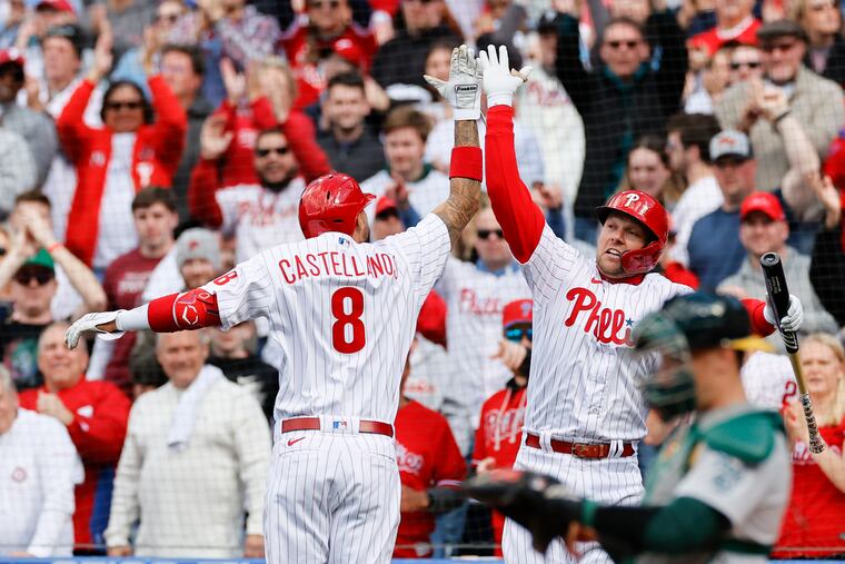 The Phillies' Nick Castellanos celebrating his first-inning home run with teammate Rhys Hoskins past Oakland Athletics catcher Sean Murphy on Saturday in Philadelphia.