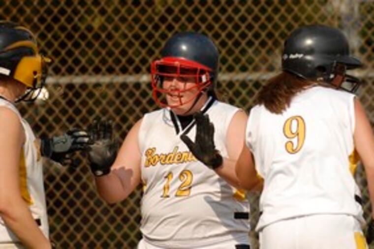 Bordentown's Nicole Walls (center) is congratulated by teammates after scoring on a passed ball.