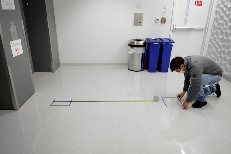 Kevin Gonzales, director of operations at the Rajen Kilachand Center for Integrated Life Sciences and Engineering at Boston University, placed safe distancing floor markings near an elevator on the school's campus, in Boston on May 21.
