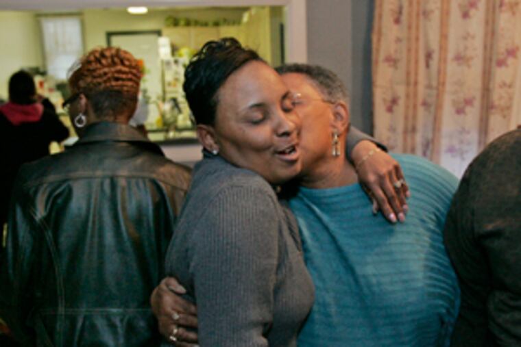 April Brown (center) gets a hug from her aunt Alice Werts. Brown's fiance , Charles Baldwin, was killed when a stray bullet pierced his second-floor window as he was preparing for work.