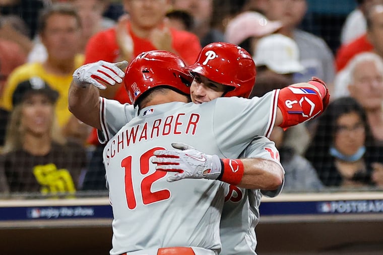 Kyle Schwarber and J.T. Realmuto embrace after Schwarber's 488-foot homer in Game 1 of the National League Championship Series in San Diego.