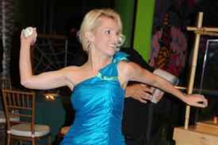 Heidi Strobel Hamels uncorks a fastball at the Hamels Foundation benefit carnival at the Please Touch Museum. She threw 46 m.p.h. Monday - a bit shy of what her husband, Phillies pitcher Cole Hamels, is capable of. The couple started the foundation to assist inner-city schools.