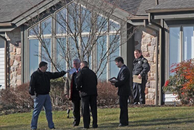 Bucks County law enforcement officers stand outside a home at 321 Swartley Drive in Hilltown Township, where a victim was killed and another kidnapped in a home invasion on Friday morning. The armed suspects remain at large. MICHAEL BRYANT / Staff Photographer