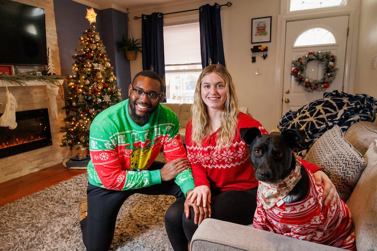 Jermaine Rhoden and Jessica Schoeffling pose with their dog, Willow, at their Philadelphia home on Friday, Dec. 8, 2023. Willow gets Christmas presents from her parents, who love to spoil their pup around the holidays.
