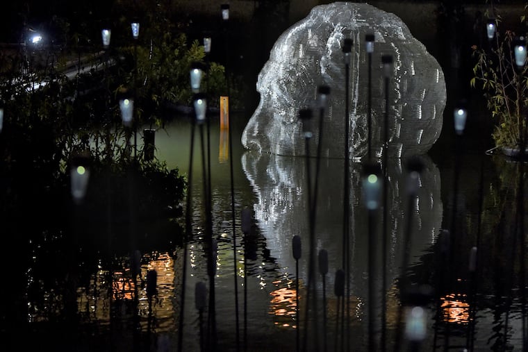 The sculpture Abu by artist Miguel Horn is crafted from translucent acrylic sheets and honors his father, an immigrant from Venezuela. It is one of the artworks in Flow, an exhibition of floating sculptural installations sited in the boat basin adjacent to the Independence Seaport Museum at Penn’s Landing on the Delaware River approaching low tide in the evening October 29, 2019.
