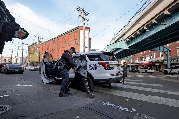 Philadelphia police take a man into custody at Kensington Avenue and G Street in March.