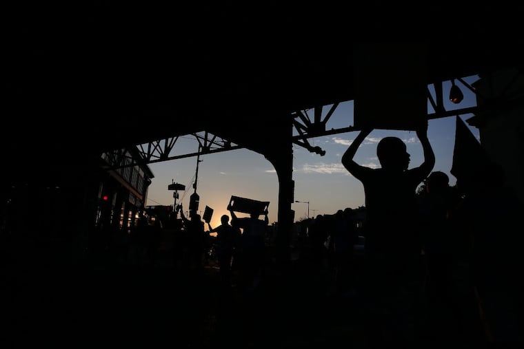 Protesters march under the El at Kensington and Allegheny Avenues during an Interfaith Peace march in Philadelphia’s Kensington section on Aug. 19, 2017. They were protesting against gun violence and drugs. DAVID MAIALETTI / Staff Photographer
