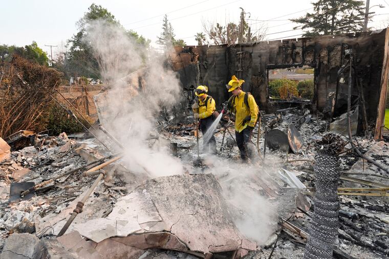 Firefighters extinguish burning embers at a house on Santa Rosa Avenue, also known as Christmas Tree Lane, after the house was destroyed by the Eaton Fire, Thursday, Jan. 9, 2025, in Altadena, Calif.
