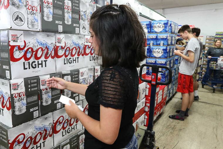Taylor Root a 15-year-old from Downingtown West High School. puts stickers on cases of beer at Joe Burns Beverage.