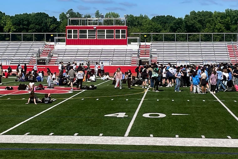 Students gather on the football field at Cherry Hill High School East Monday, May 19, 2025 after they walked out of classes to support a fired vice principal, David Francis-Maurer.