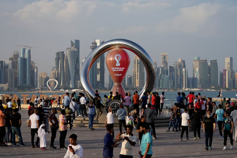 FILE - People gather around the official countdown clock showing remaining time until the kick-off of the World Cup 2022, in Doha, Qatar. (AP Photo/Hassan Ammar, File)