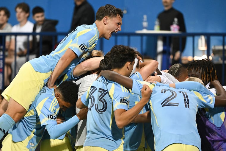 Union players celebrate together after Mikael Uhre's late winning goal against CF Montreal.