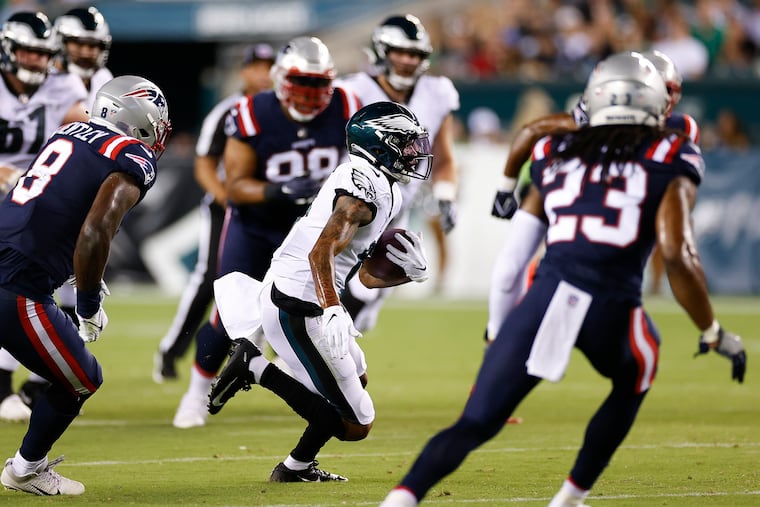 Eagles wide receiver DeVonta Smith runs with the football past New England Patriots linebacker Ja'Whaun Bentley during the second quarter in a preseason game on Thursday, August 19, 2021 in Philadelphia.