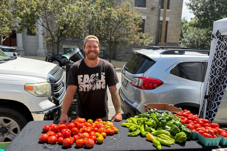 Bruce Santino, 38, selling his produce at Dickinson Square Farmers’ Market. Santino's farm is trying to keep up with the lettuce demand amid the cyclospora outbreak.
