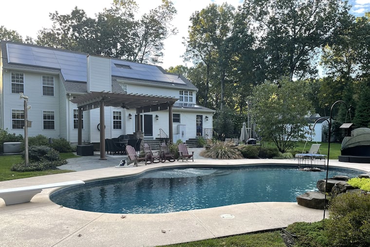The Connellys' back yard in Shamong includes a pool, patio and lots of trees. The solar panels supply half of their energy needs.
