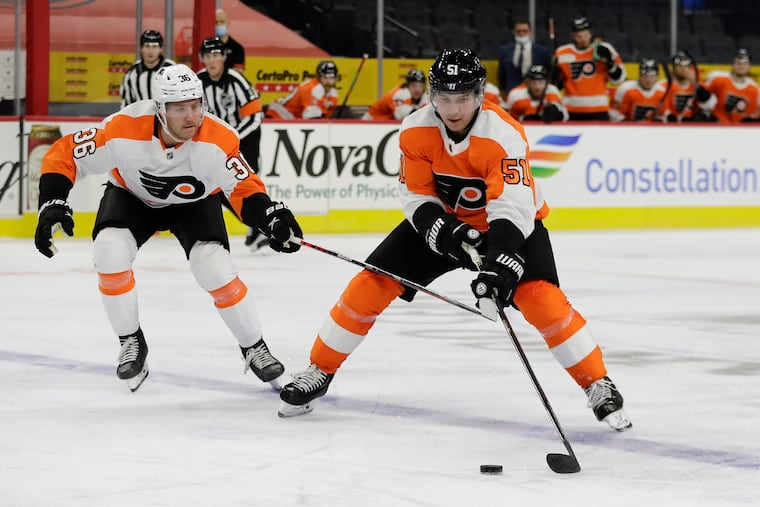 Flyers defenseman Derrick Pouliot skates with the puck against right winger Linus Sandin during an intrasquad game Jan. 10 at the Wells Fargo Center.