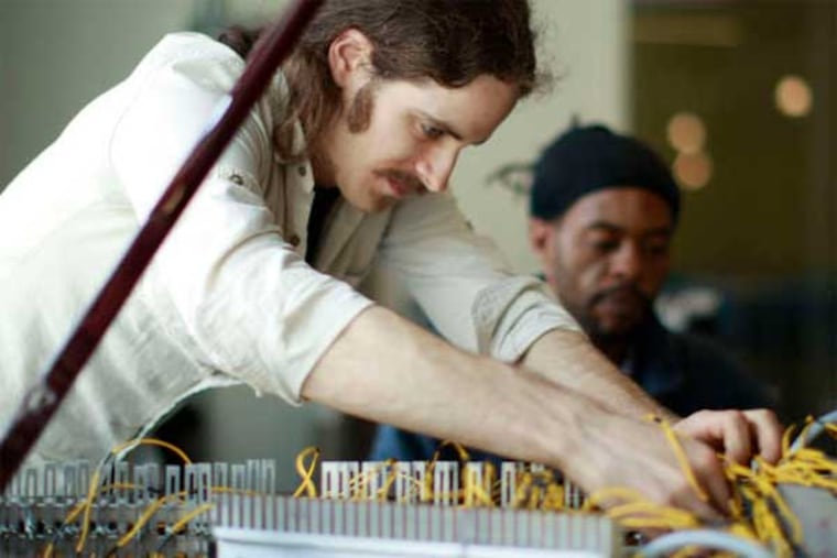 Doctoral student Jeff Gregorio (left) shows jazz pianist Marc Cary a modified piano whose strings are electromagnetically vibrated. (David Swanson / Staff Photographer)