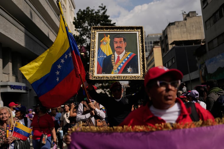 A government supporter holds an image of Nicolás Maduro during a women's march to demand his return in Caracas, Venezuela, on Tuesday, Jan. 6, three days after U.S. forces captured him and his wife.