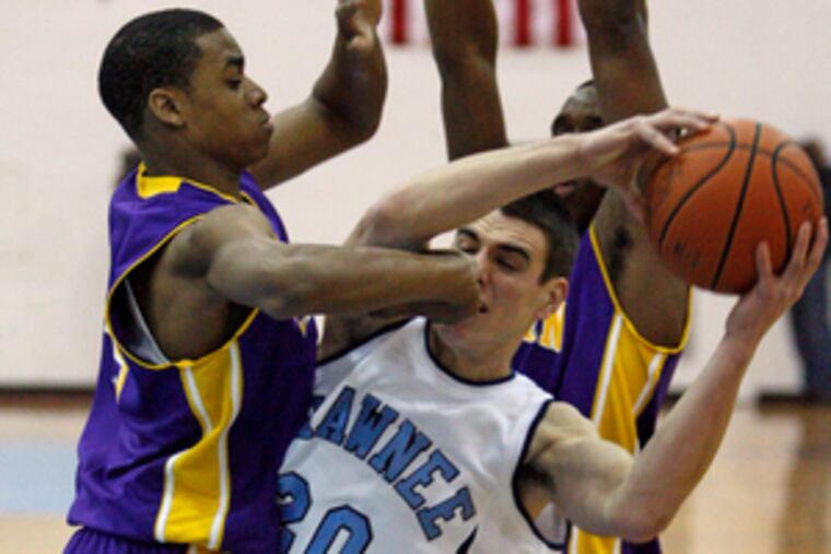 Shawnee's Doug Holcombe gets a hand in the face from Camden's Khalil Mims during the Renegades' overtime win in a South Jersey group 3 quarterfinal Feb. 28. See G.